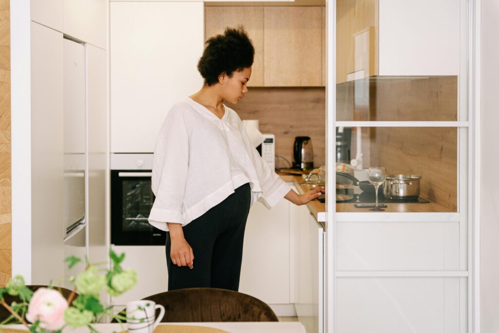 Woman standing in kitchen, holding onto counter